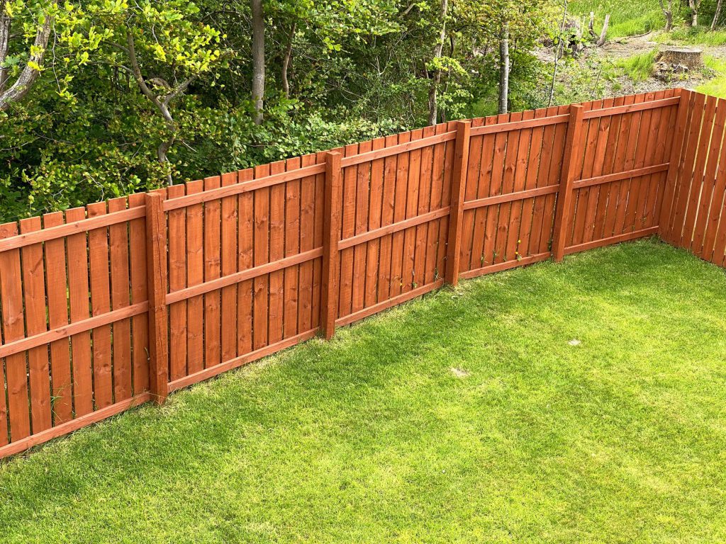 A cedar fence being stained in the Pacific Northwest