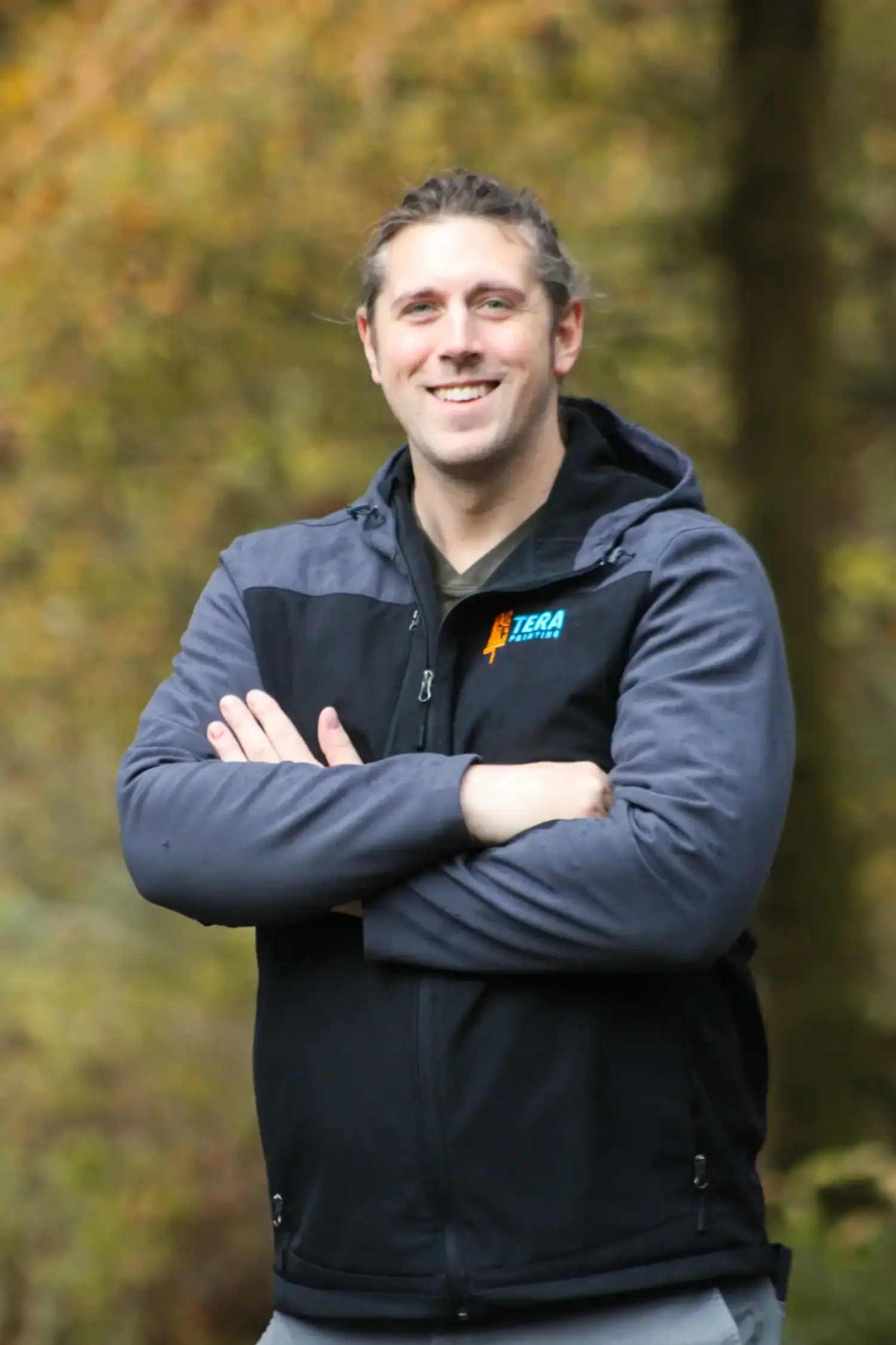 Tera Painting owner Matt Houghton posing with arms crossed in a dark jacket