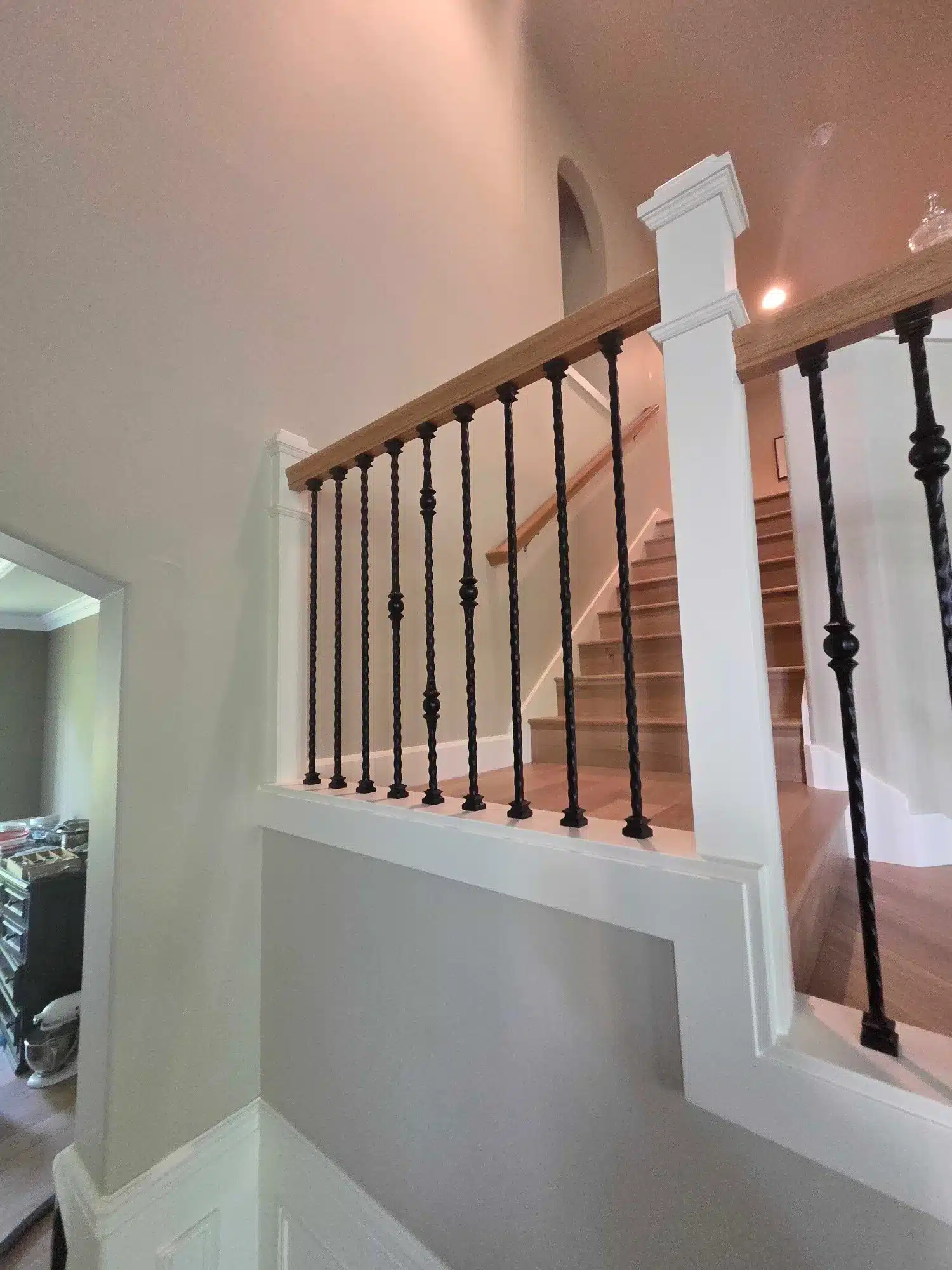 White Painted Staircase Railing White-painted staircase with wood handrail, black turned balusters, and white newel posts in residential interior